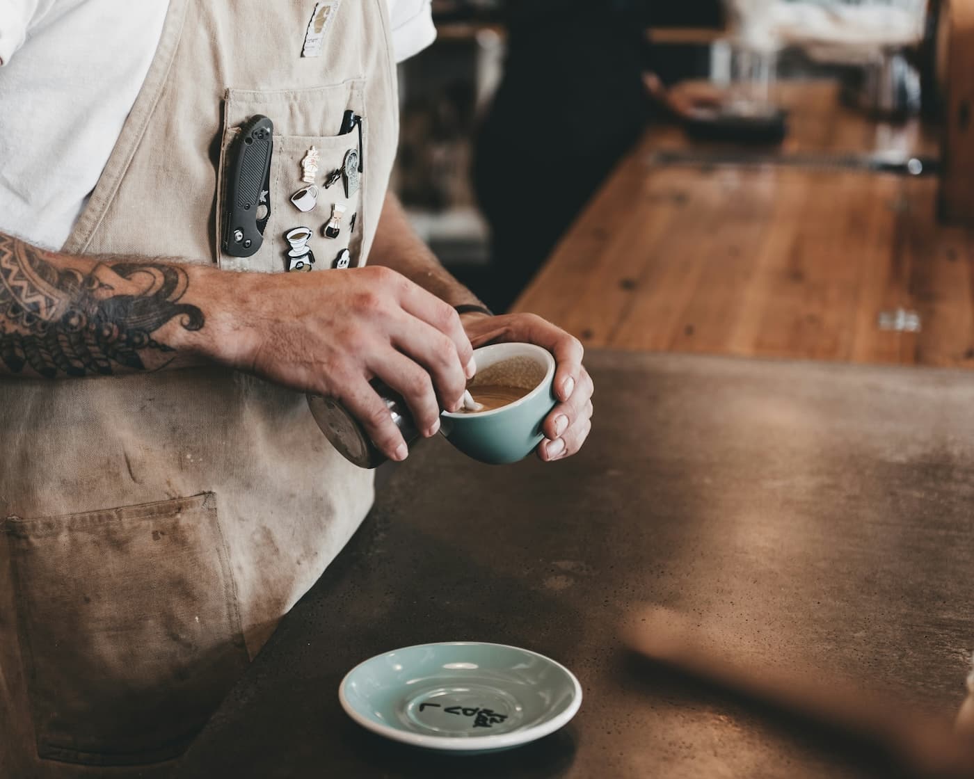 Overhead shot of someone pouring frothed milk into a latté cup.